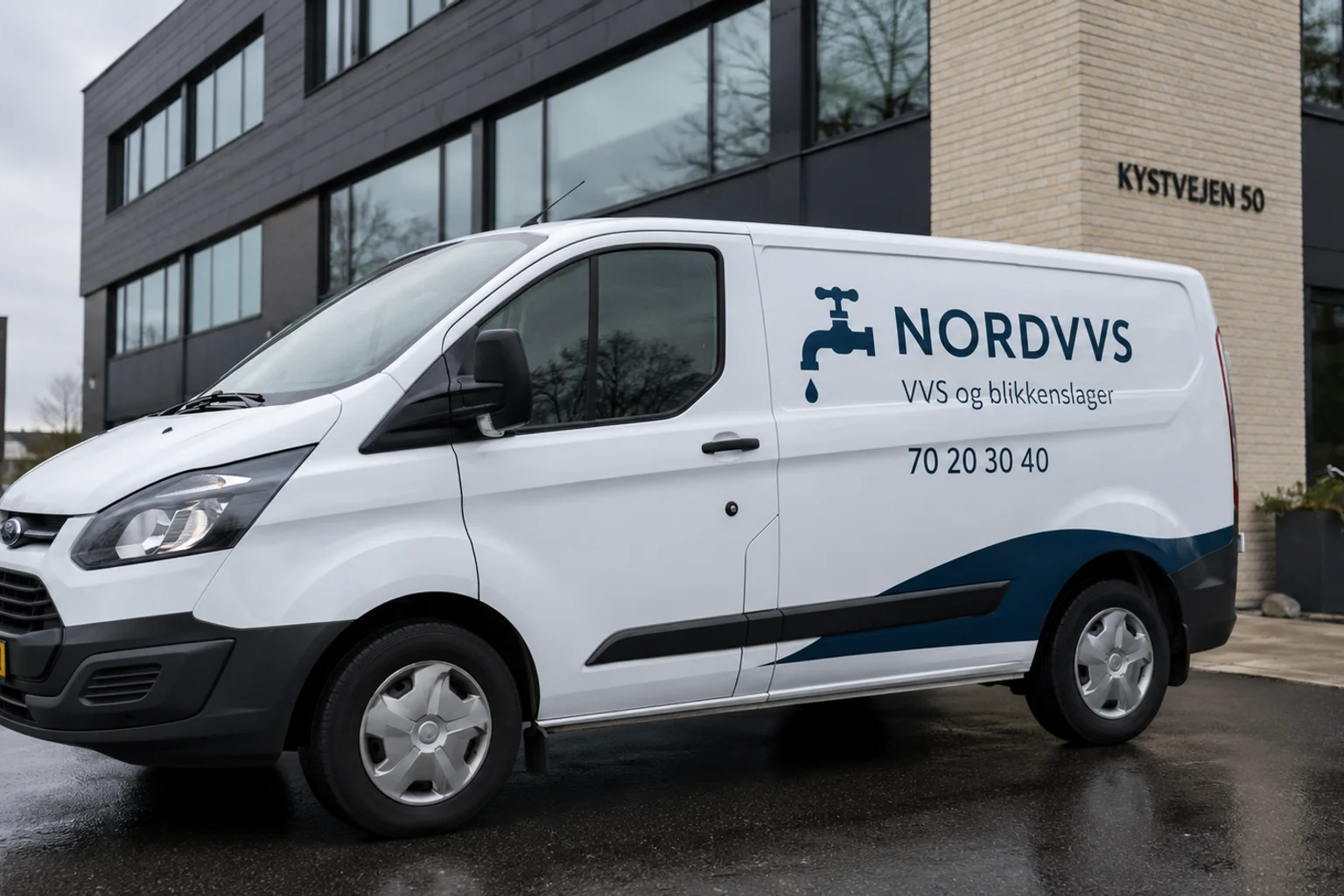Hvid leaset varevogn med delvis reklamefolie for VVS-firma foran kontorbygning